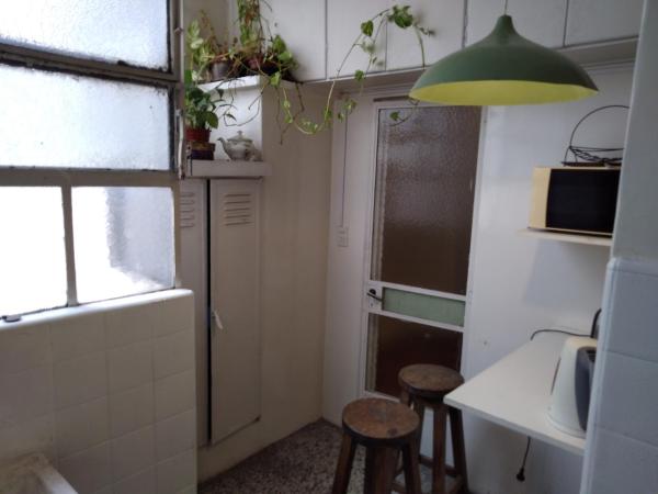 una pequeña cocina con 2 taburetes y una lámpara verde en Apartamento todo entero en Buenos Aires
