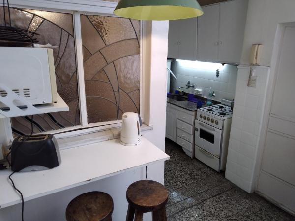 una cocina con barra y dos taburetes. en Apartamento todo entero en Buenos Aires