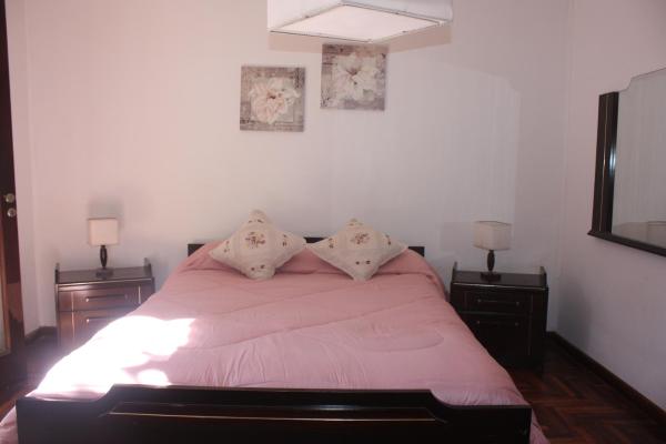 1 dormitorio con 1 cama con sábanas rosas y 2 lámparas en DEPARTAMENTO FAMILIAR en Mar del Plata