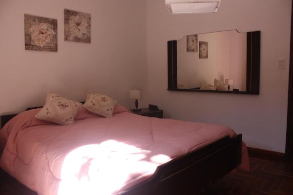 1 dormitorio con 1 cama con sábanas rosas y espejo en DEPARTAMENTO FAMILIAR en Mar del Plata