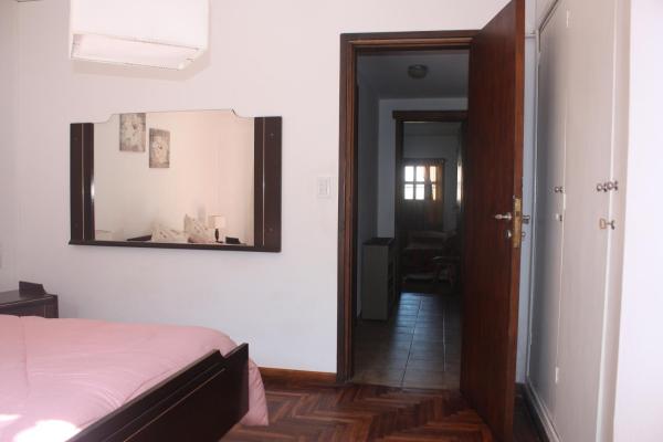 1 dormitorio con cama y espejo en la pared en DEPARTAMENTO FAMILIAR en Mar del Plata