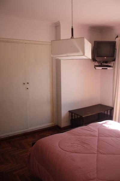 1 dormitorio con 1 cama y TV en la pared en DEPARTAMENTO FAMILIAR en Mar del Plata