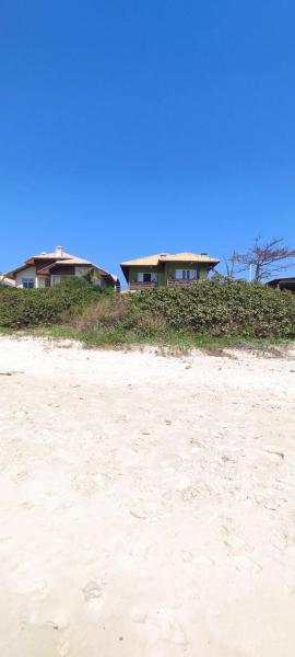 un par de casas en una playa de arena en NaPraia Mariscal, en Bombinhas