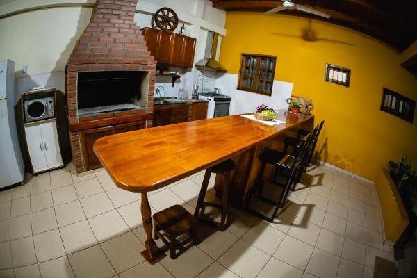 cocina con mesa de madera y encimera en La Posada de Moncho en Puerto Iguazú