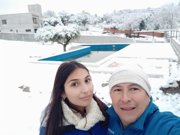 un hombre y una mujer de pie en la nieve en SIMION en Villa Carlos Paz
