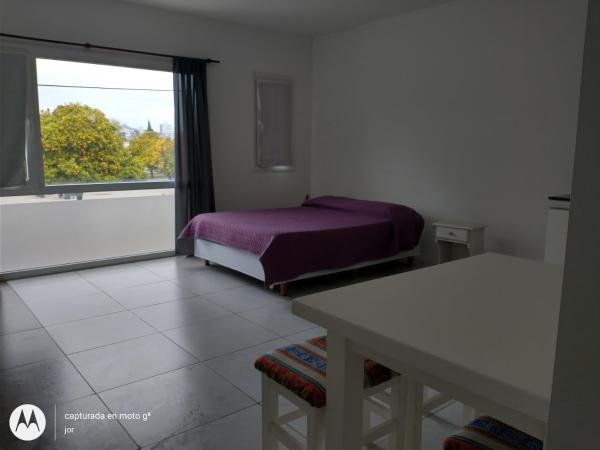 1 dormitorio con cama, ventana y mesa en Departamento Serrano en Tandil