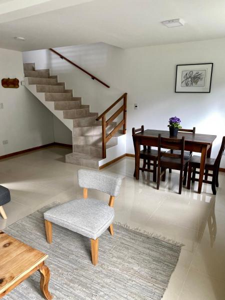 sala de estar con mesa y sillas y escalera en Terrazas de la Patagonia en Esquel