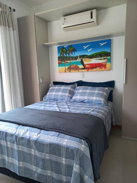 1 dormitorio con 1 cama con manta azul y blanca en Viapiana Cobertura 301, en Bombinhas