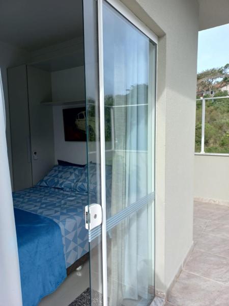 una puerta de cristal que conduce a un dormitorio con cama en Viapiana Cobertura 301, en Bombinhas