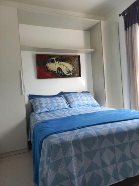 1 dormitorio con 1 cama con una pintura de coche en la pared en Viapiana Cobertura 301, en Bombinhas