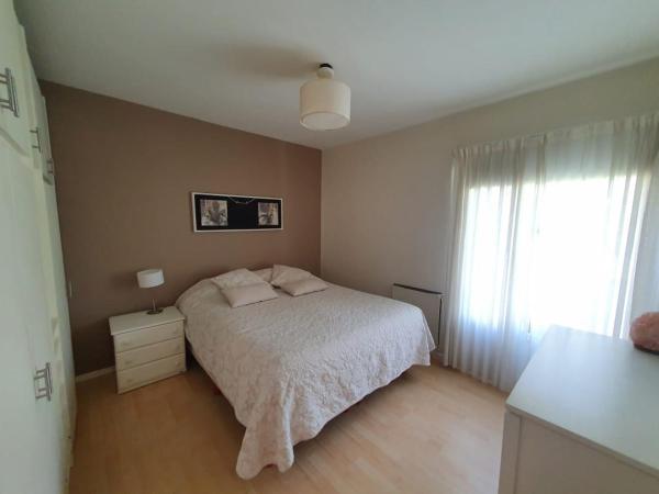 1 dormitorio con cama blanca y ventana en Casa Golfo Nuevo en Puerto Madryn