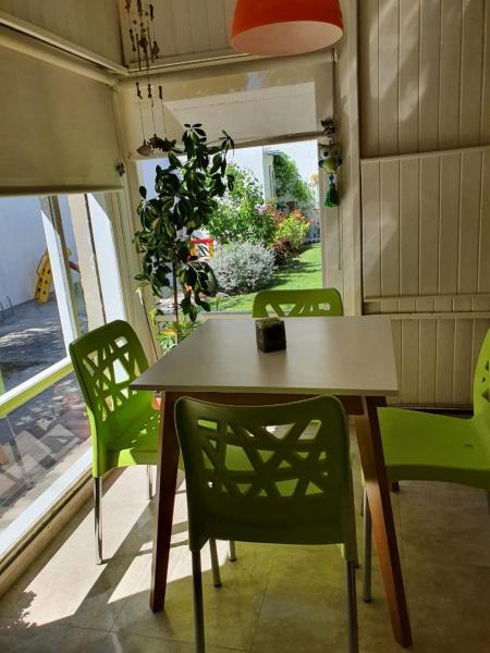 mesa y sillas en una habitación con ventana en Casa Golfo Nuevo en Puerto Madryn