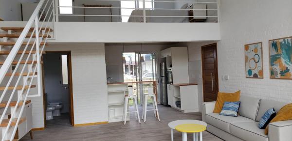 a living room with a loft bed and a kitchen at RANTALOMA Lofts in Piriápolis