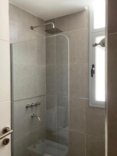 baño con ducha y puerta de cristal en Eqqus en Pinamar