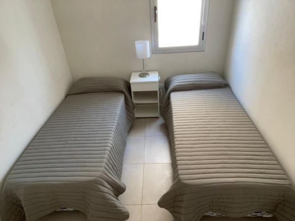 2 camas en una habitación pequeña con ventana en Eqqus en Pinamar