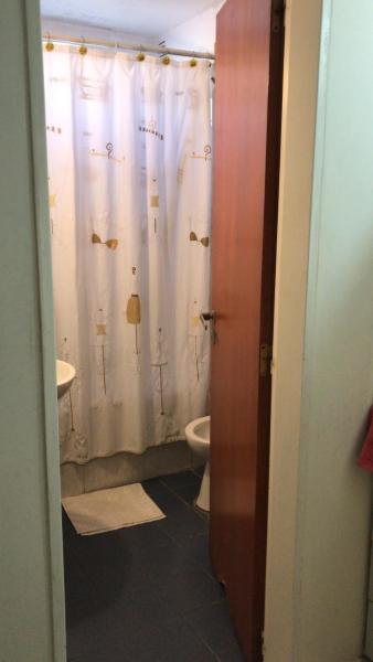 y baño con aseo y cortina de ducha. en Belgrano 9 en Salta