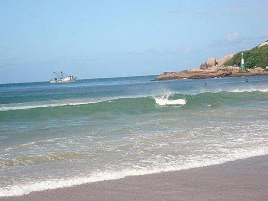 a large body of water with a boat in the ocean at Olhar da Barra Hospedagem - Refugio Urbano I in Florianópolis