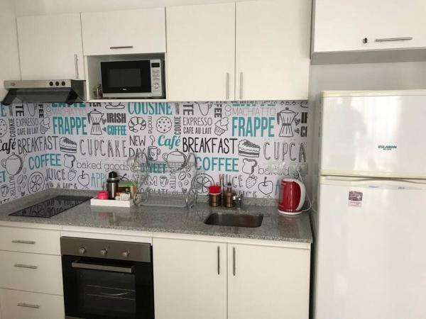 una cocina con armarios blancos y una pared cubierta de graffiti en Apartamento a pasos de Cañitas y Palermo Hollywood en Buenos Aires