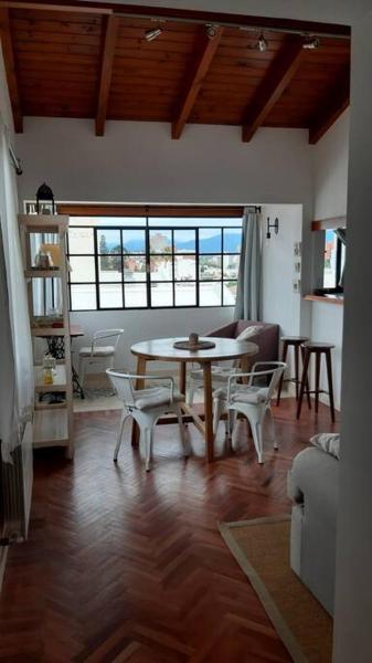 sala de estar con mesa y sillas en Hermoso departamento céntrico en ultimo piso, con cochera en Salta