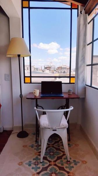 escritorio con ordenador portátil y silla frente a una ventana en Hermoso departamento céntrico en ultimo piso, con cochera en Salta