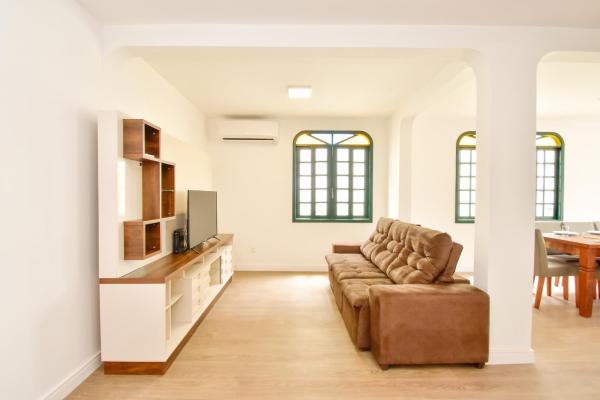 a living room with a couch and a table at Casa suspensa, ampla cobertura duplex a duas quadras da praia em Canasvieiras N693 in Florianópolis
