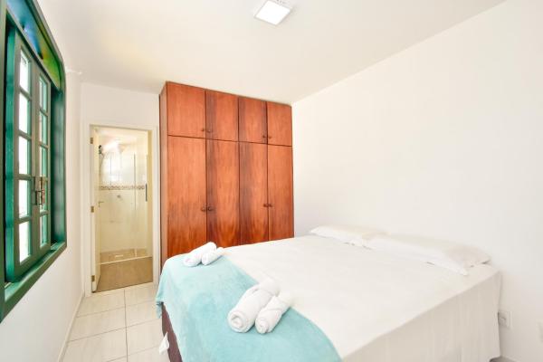 a bedroom with a bed and a wooden cabinet at Casa suspensa, ampla cobertura duplex a duas quadras da praia em Canasvieiras N693 in Florianópolis