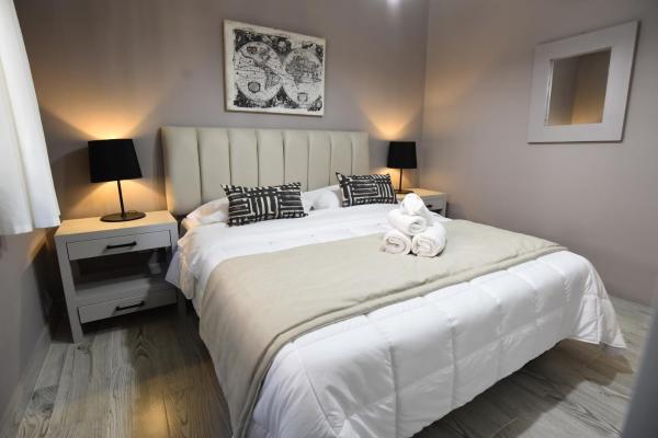 1 dormitorio con 1 cama blanca grande y 2 almohadas en Altos de Pinamar en Ostende