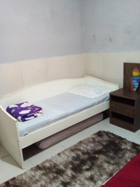 a small bedroom with a bed and a table at Casa a uma quadra da praia da Armação in Florianópolis