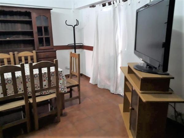 una sala de estar con televisión de pantalla plana y sillas en Veranogesell en Villa Gesell