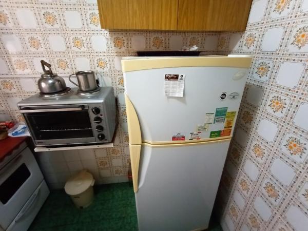 una pequeña cocina con refrigerador y microondas en EFDEPARTAMENTOS plaza colon monoambiente en Mar del Plata