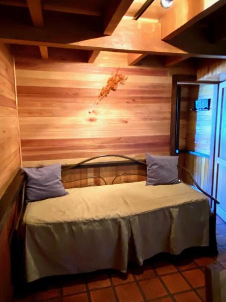 Cama en habitación con pared de madera en Inmejorable ubicación en San Martín de los Andes