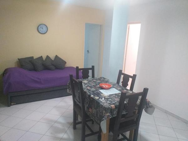 1 dormitorio con mesa y 1 cama con sábanas moradas en Serena en Villa Carlos Paz