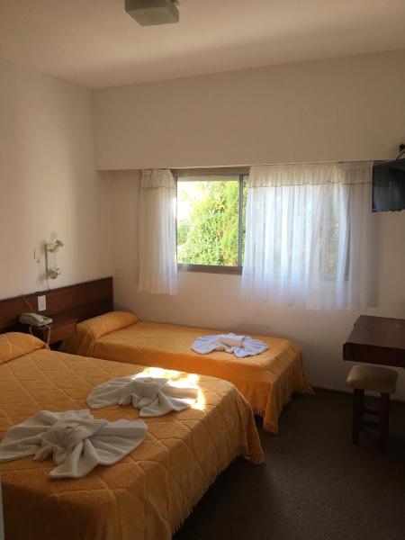Dos camas en una habitación con toallas.  en Hostería Santa Bárbara en Villa Gesell