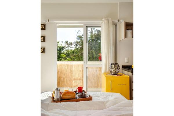 a bed with a tray of bread and a window at Zen Space in Curitiba