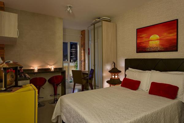 a hotel room with a bed with red pillows at Zen Space in Curitiba