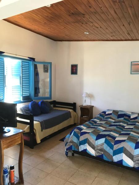 1 dormitorio con 2 camas y techo de madera en La Casa Azul: tranquilidad y esparcimiento en un entorno natural en Chascomús
