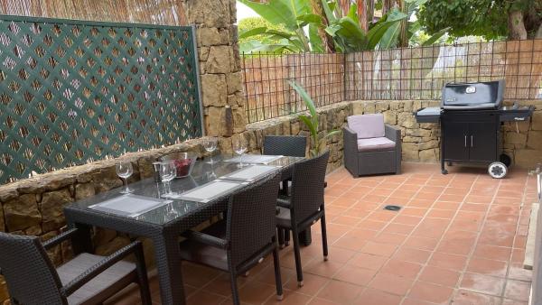 una mesa y sillas con copas de vino en el patio en Sierra Carzola, en Marbella