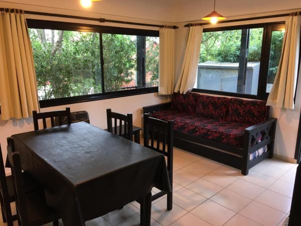 una sala de estar con un sofá y una mesa y sillas en Los Paraisos de Villa Gesell
