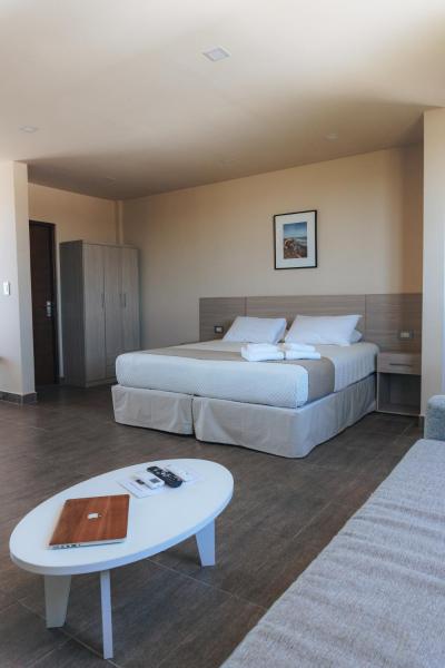Habitación de hotel con 2 camas y mesa de centro en Solana - Apart Hotel & Club de Tenis en Santa Clara del Mar