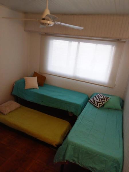 en room with 2 green beds and window at Encantador departamento frente al mar 4 Con in Villa Gesell