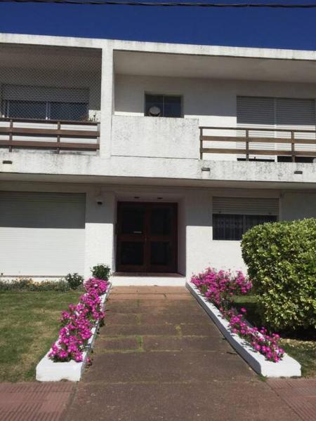 una casa con flores rosas delante de ella en Ya encontraste tu apartamento en Punta del Este! Playa mansa, en Punta del Este