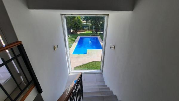 un pasillo con vistas a la piscina a través de una ventana en Casa Villa Nueva en Mendoza