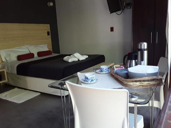 1 dormitorio con 1 cama, mesa de cristal y sillas en Aguamansa, en Las Gaviotas