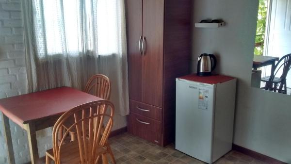 cocina pequeña con mesa y refrigerador pequeña en Hosteria Nido de Condores, en Mina Clavero