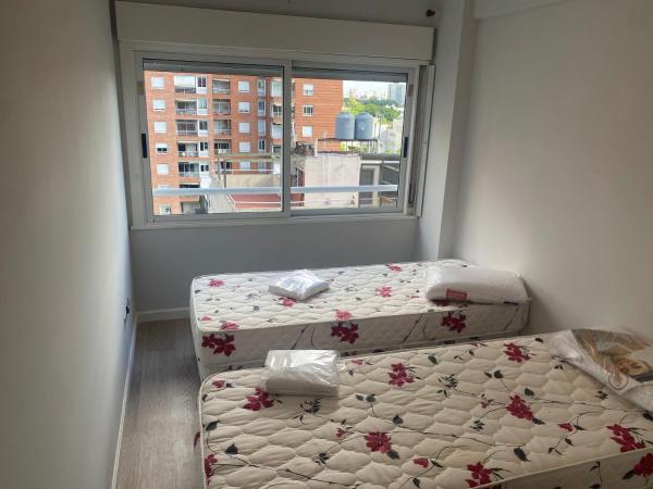 2 camas en una habitación con ventana en espectacular departamento en Nuñez en Buenos Aires