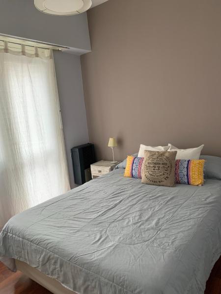 1 dormitorio con 1 cama grande con almohadas y ventana en Hermoso departamento a la calle a 300 mts del mar en Mar del Plata