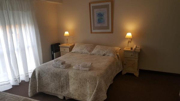 un dormitorio con una cama con dos toallas en la Hostería Esturion Village en Villa Gesell