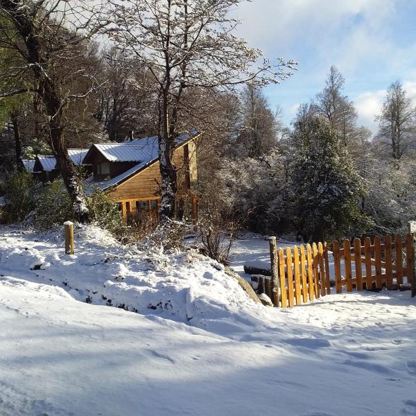 una casa en la nieve con una valla de madera en Reina Mora, Reserva Patagonica en San Martín de los Andes