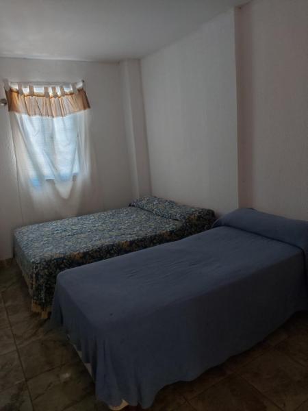 2 camas en una habitación pequeña con ventana en Wonderful en Puerto Iguazú