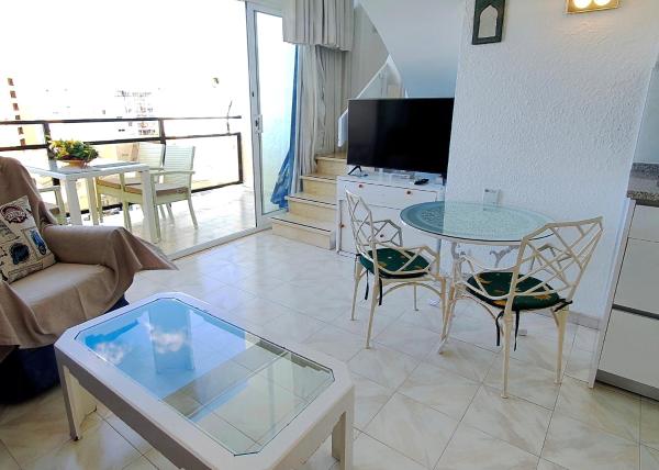 sala de estar con mesa y sillas en Skol 701. One Bedroom Duplex with Exceptional Sea Views., en Marbella
